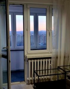 a room with windows and a view of a city at Panorama Apartment Kraków in Krakow