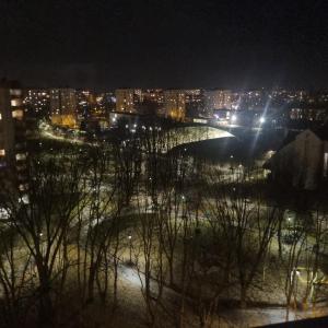 - une vue sur la ville la nuit avec des lumières dans l'établissement Panorama Apartment Kraków, à Cracovie