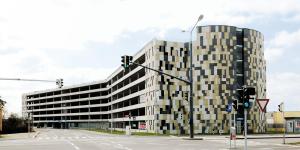 ein hohes Gebäude auf einer Straße mit Ampel in der Unterkunft SMART-SCHÖN-Günstig,nähe U1 & Park and Ride ! in Wien
