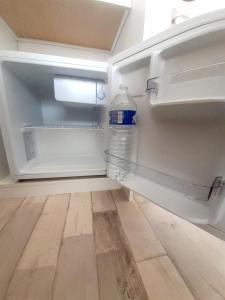 um frigorífico vazio com uma garrafa de água em Hotes'Octon em Octon