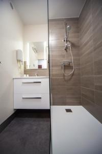 La salle de bains est pourvue d'une douche et d'un lavabo. dans l'établissement Kyriad Laon, à Laon