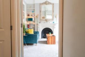 a living room with a blue couch and a fireplace at WiFi | Near Major Attractions in Bath