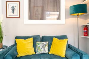 a blue couch with yellow pillows in a living room at WiFi | Near Major Attractions in Bath