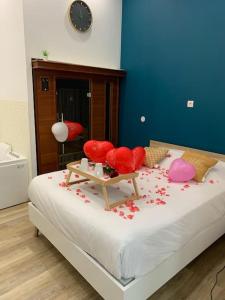 um quarto com uma cama com flores vermelhas em Appartement Spa - NAHLEO Scandinave em Dole