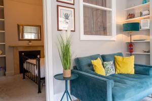 a blue couch with yellow pillows in a living room at WiFi | Near Major Attractions in Bath +24 photos