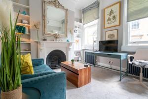 a living room with a blue couch and a fireplace at Elegant 1Br apartment central Bath in Bath