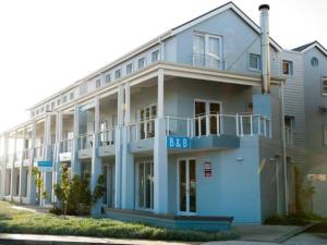 クニスナにあるCrow's Nestの時計付きの青い大きな建物