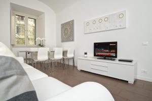 sala de estar con muebles blancos y TV de pantalla plana en Germanico Maxi, en Roma
