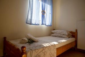 a bedroom with a bed with a window with blue curtains at Aegina Sea View Villa in Aegenitissa