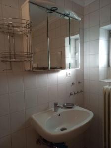 uma casa de banho branca com um lavatório e um espelho em Ferienwohnung Hellweg em Herford
