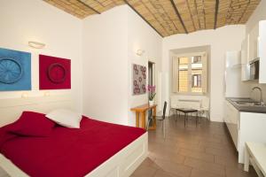 ローマにあるGermanico Maxiのベッドルーム1室(赤いベッド1台付)、キッチンが備わります。