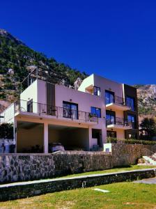 a house on a hill with a stone wall at Marea DeLuxe Apartments in Kotor