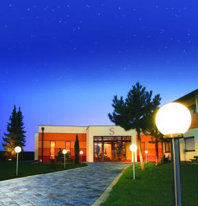 a building with lights in front of it at night at Hotel garni Steinfeld in Wiener Neustadt