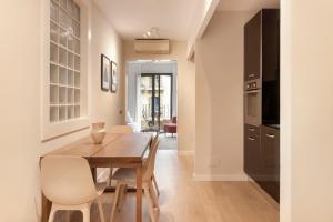 cocina y comedor con mesa de madera y sillas en C211 Barcelona Apartments, en Barcelona