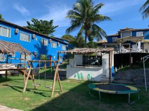 um parque infantil em frente a um edifício azul em Pousada Laguna Búzios em Búzios