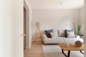 a white living room with a couch and a table at C211 Barcelona Apartments in Barcelona