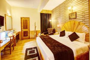 a hotel room with a large bed and a desk at Hotel Apple Paradise Manali in Manāli