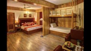 a bedroom with two bunk beds and a couch at Hotel Apple Paradise Manali in Manāli