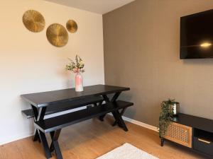 a black dining room table with a vase of flowers at Ashvale, Cambridge in Chesterton