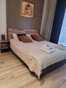 a bedroom with a large bed with towels on it at Apartament przy Starówce in Elblag