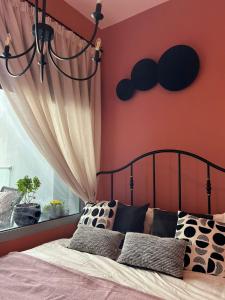 a bedroom with a bed with orange walls and a window at Stylish studio in Masdar in Abu Dhabi