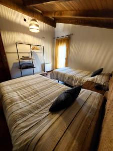 的住宿－El Descanso de Las Hurdes，卧室配有两张床和枕头,位于地板上