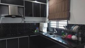 a kitchen with a sink and a counter top at D'Sandra Homestay in Kulim