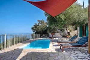 a swimming pool with two chairs and a red umbrella at Villa Levrecchio in Longós