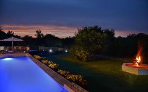 - une piscine avec des lumières bleues dans une cour la nuit dans l'établissement Kruger Safari Lodge, à Domaine de chasse de Manyeleti