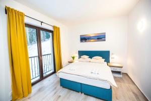 a bedroom with a large bed and a large window at Spa Apartments St. Moritz in Mariánské Lázně +19 photos