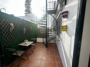 Un patio con mesa y sillas y una escalera. en Apartamento Beach&Relax Chipiona, en Chipiona
