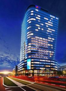 a tall building with lights on in a city at Hanza Tower Casino & Pool & Jacuzzi & Sauna in Szczecin