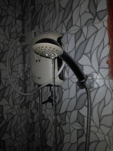 uma cabeça de chuveiro numa casa de banho com em Jean apartments em Panglao