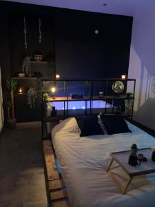 a bedroom with a bed with a table on it at Appartement Spa - NAHLEO Industriel in Dole