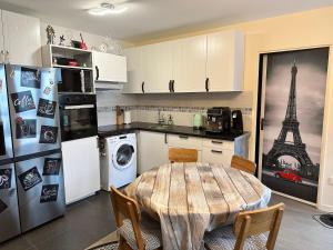 uma cozinha com uma mesa numa cozinha com a Torre Eiffel em Charmant appartement sacré cœur avec parking gratuit em Paris