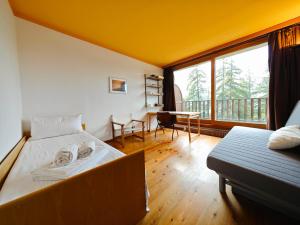 a bedroom with a bed and a desk and a window at Hostdomus - Sansicario R4 in Cesana Torinese
