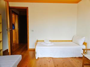 a bedroom with a white bed and a door at Hostdomus - Sansicario R4 in Cesana Torinese