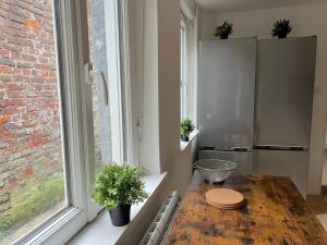 a kitchen with a wooden table in front of a window at Maison Cosy 5 chambres 3 SDB proche Lille in Roubaix