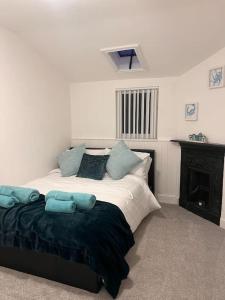 a bedroom with a large bed with blue pillows at Ivy Cottage in Prestatyn