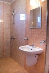 a bathroom with a sink and a shower with a mirror at Guest House Moiata Kashta in Chernomorets +17 photos
