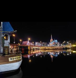 a boat is docked in the water at night at Hanza Tower Casino & Pool & Jacuzzi & Sauna in Szczecin
