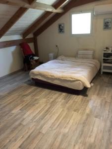 a large bed in a room with a wooden floor at Lakeview Chalet in the Galilee - Master Bedroom Sublet in Kafr Mandā