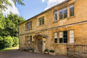 an old brick building with a door and windows at Classic Cotswolds Apartment, The Little Coach House in Blockley