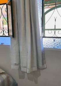 a window with white curtains in a room at Quartos Masculino - Romas House in Itu