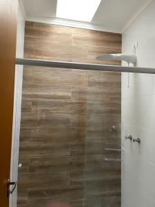 a shower with a glass door in a bathroom at Quartos Masculino - Romas House in Itu