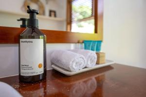 una bottiglia di sapone e due asciugamani su un tavolo di Cedia at Byron Bay Hinterland a Byron Bay