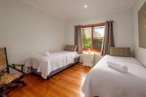 una camera da letto con due letti e una finestra di Cedia at Byron Bay Hinterland a Byron Bay Altre 29 foto