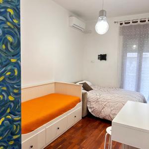 um quarto com uma cama com um colchão laranja em Maison Milù di Mediterranea Host em Taranto