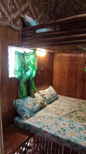a bed in a wooden room with a bed sidx sidx sidx at Moalboal Bamboo House / Rooms in Moalboal