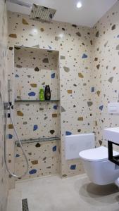 bagno con parete ricoperta di formazioni rocciose di 2E Center Apartment a Tirana